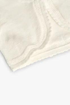 Bolero in maglia per neonata in bianco.