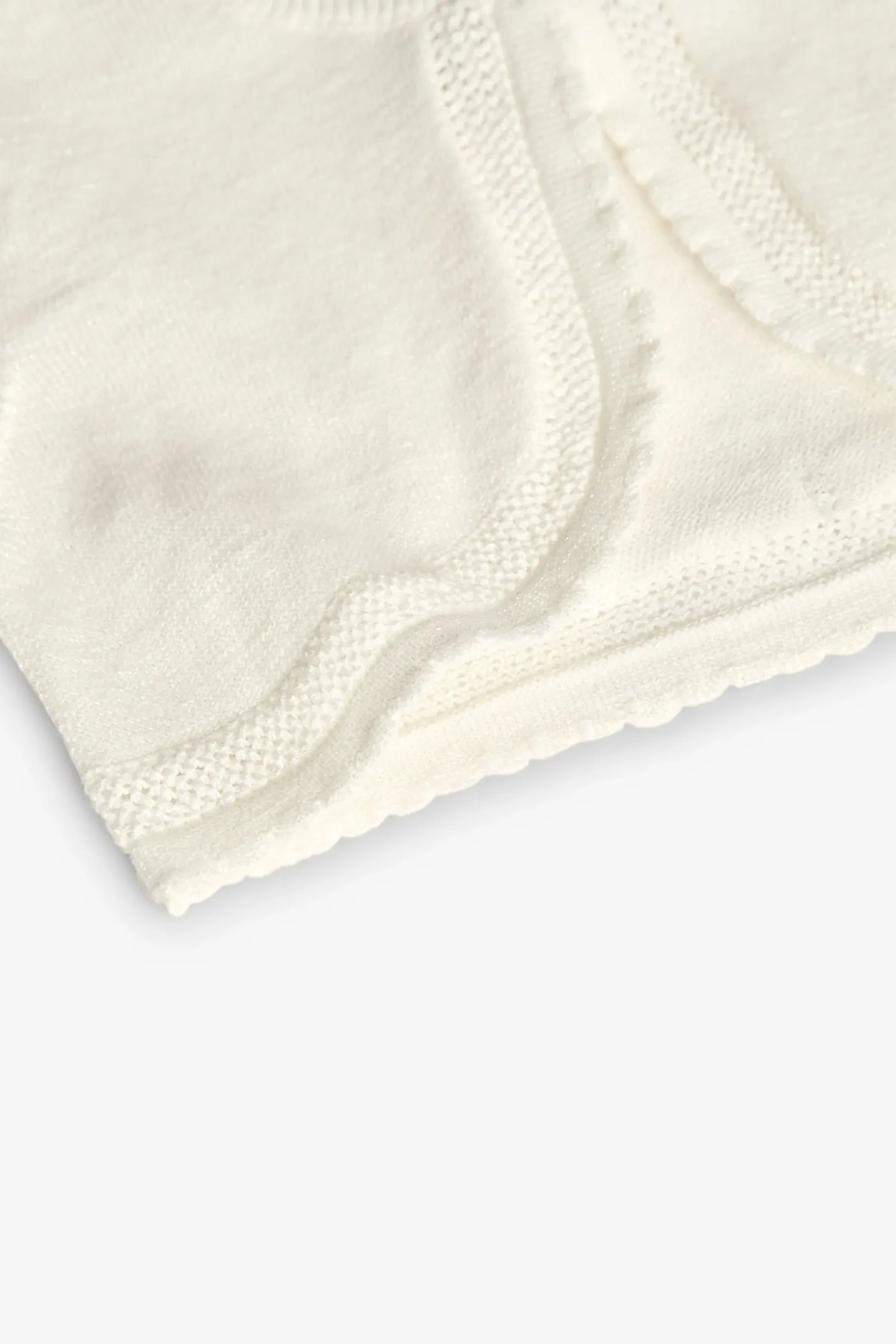 Bolero in maglia per neonata in bianco.