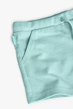 Completo di maglietta e pantaloncini a maglia per neonata di colore bianco.