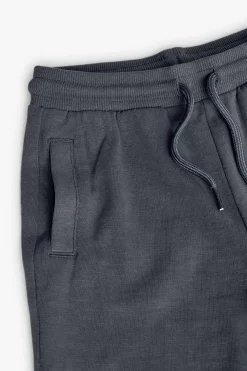 Completo in maglia con maglietta per bambino di colore bianco e bermuda di colore grigio.