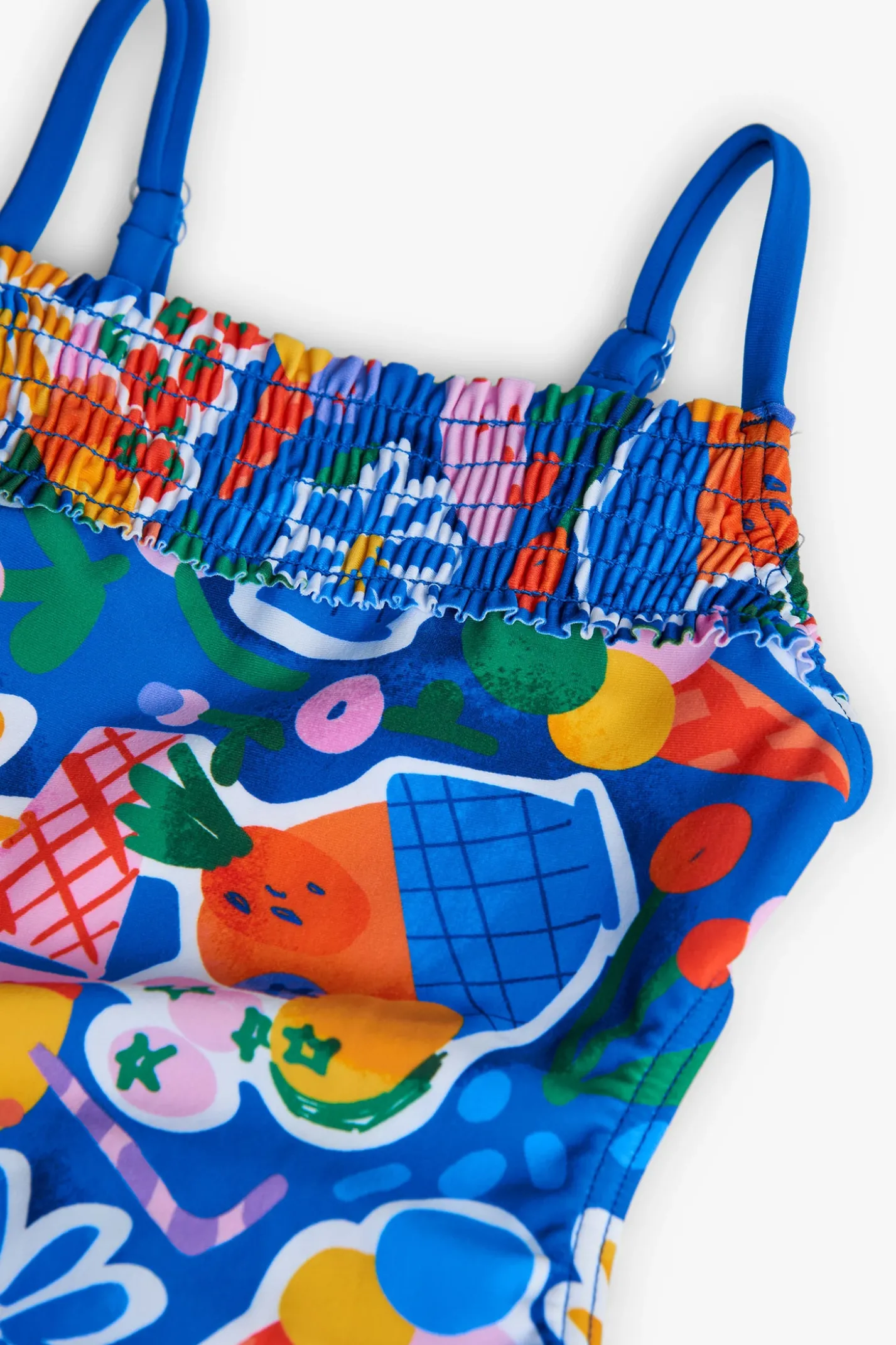 Costume da bagno in poliammide per bambina con stampa di frutta e fiori in colore blu.