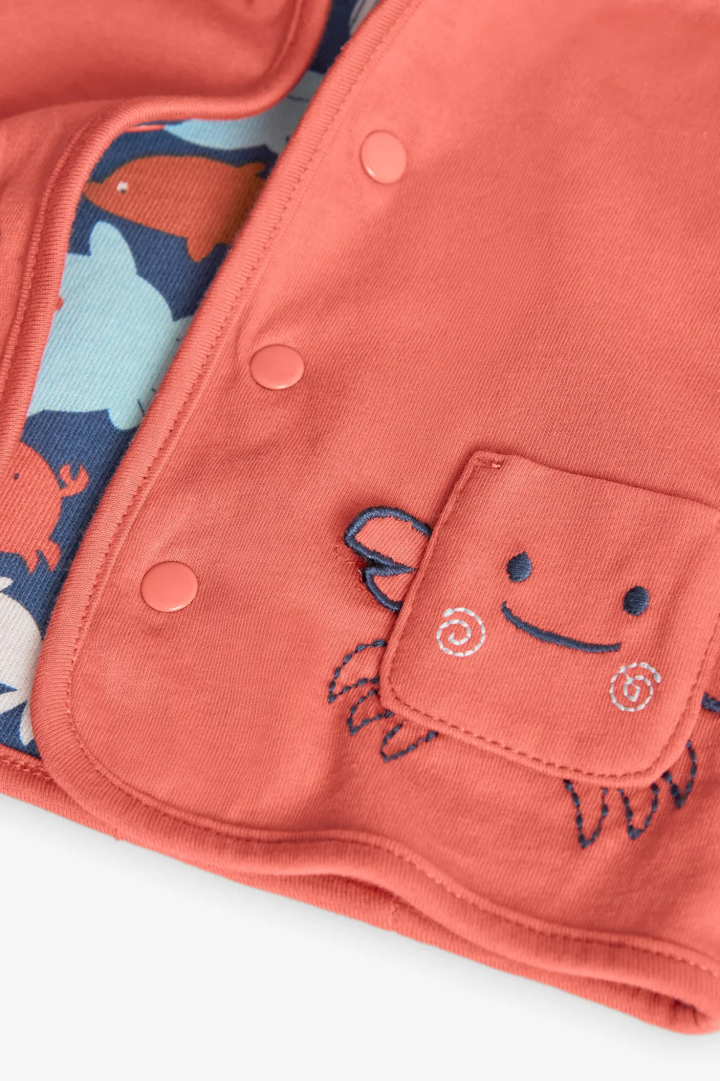 Giacca reversibile a maglia per neonato in colore rosso e con stampa.