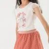 Maglietta a maglia per bambina in bianco con disegno di fiori