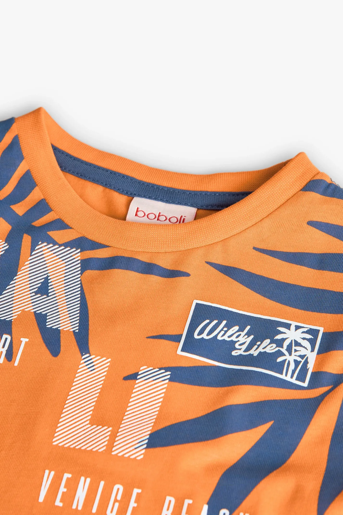 Maglietta a maglia per bambino in arancione a maniche lunghe.