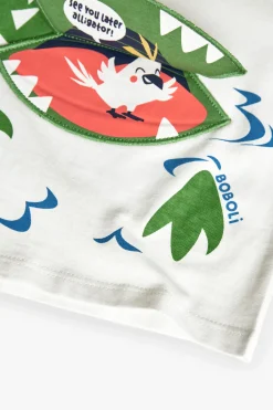 Maglietta a maglia per bambino in bianco con design di coccodrillo.