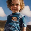 Maglietta in maglia per bambino di colore blu con design tropicale.