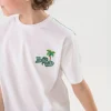 Maglietta in maglia per bambino bianca con design di leone surfista