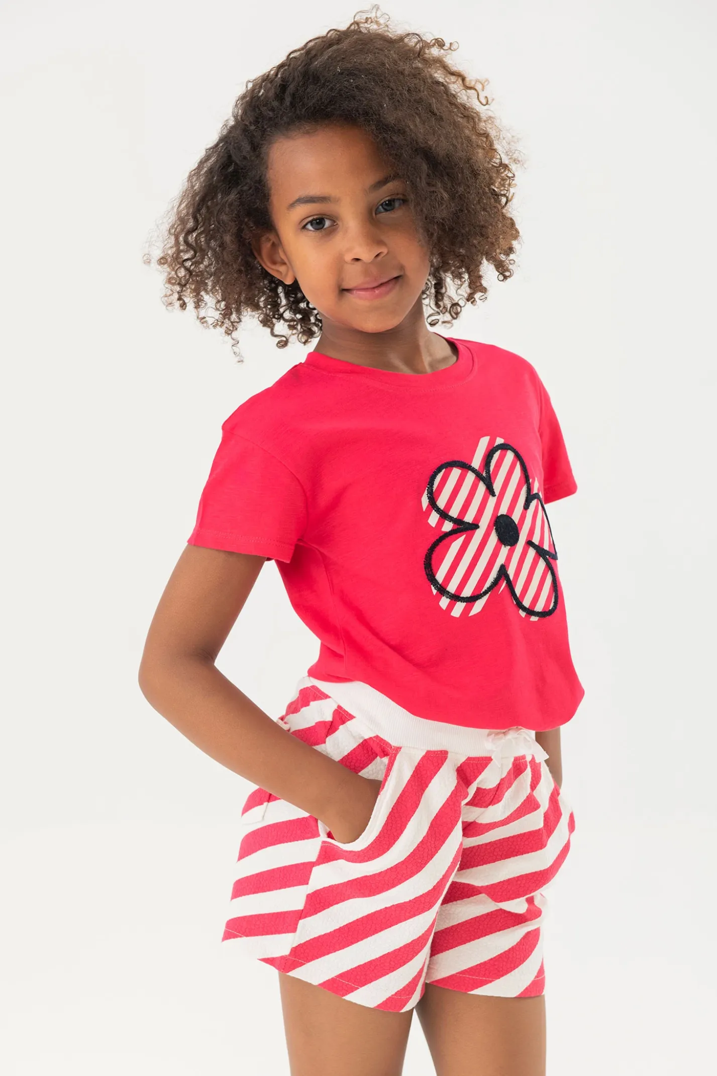 Maglietta in maglia per bambina di colore fragola con motivo floreale.