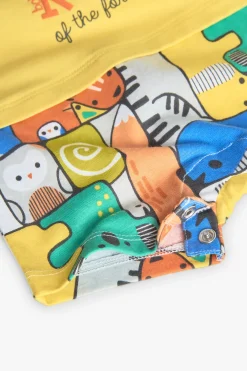 Pagliaccetto corto a maglia per neonato di colore giallo.