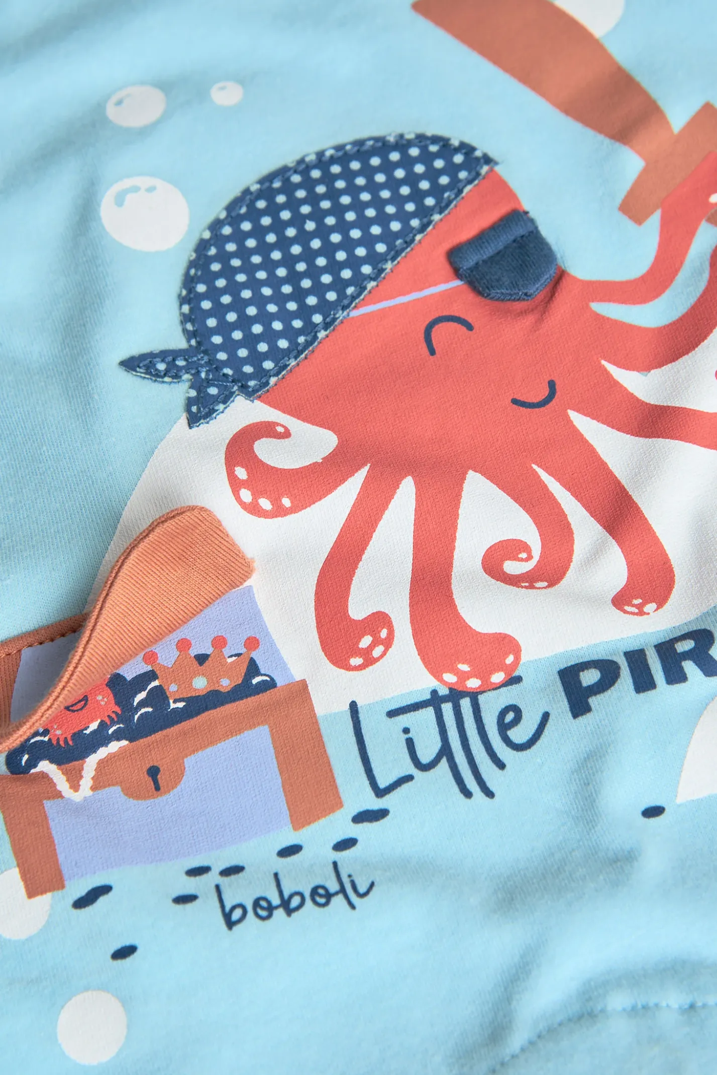 Pagliaccetto corto in maglia per neonato in colore blu con stampa di polpo pirata.