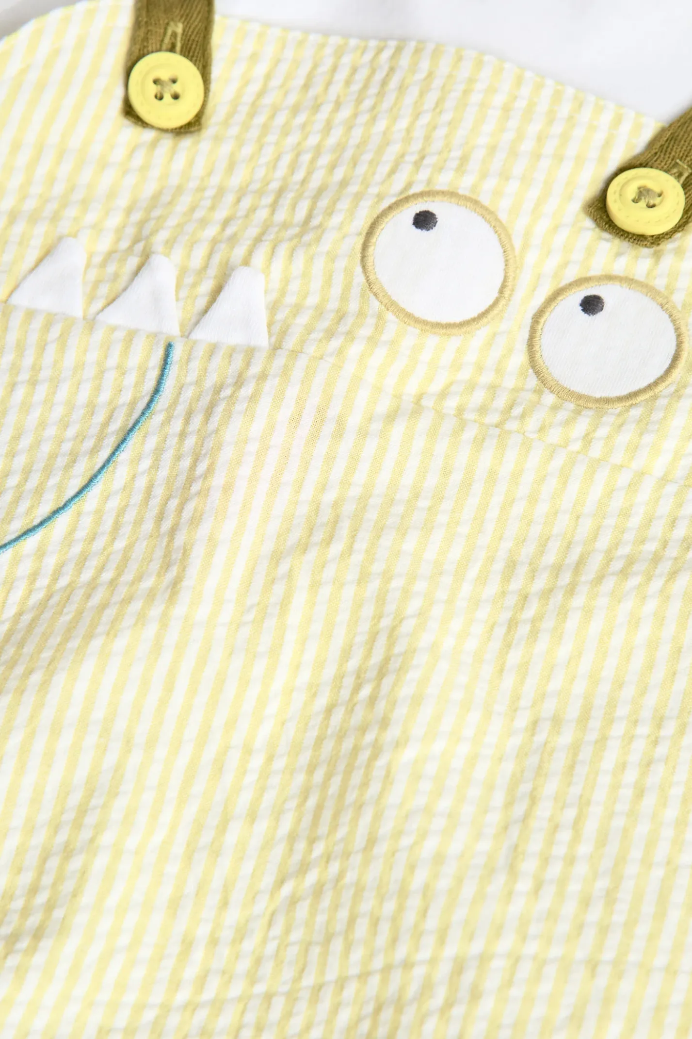 Pagliaccetto in popeline per neonato a righe di colore giallo.
