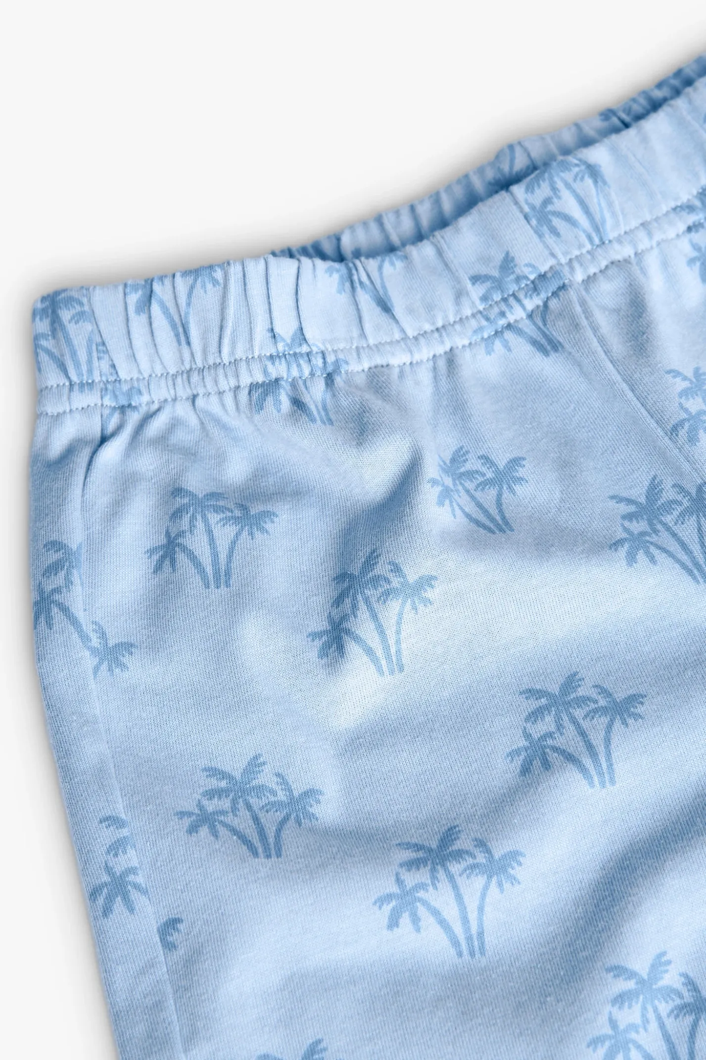 Pigiama corto in maglia per bambino con stampa in colore blu.