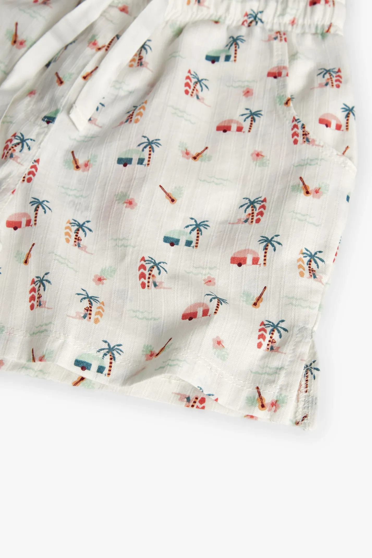 Short in batista per bambina con stampa tropicale in colore chiaro.