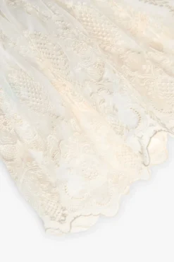 Vestito di tulle per bambina ricamato in colore bianco.